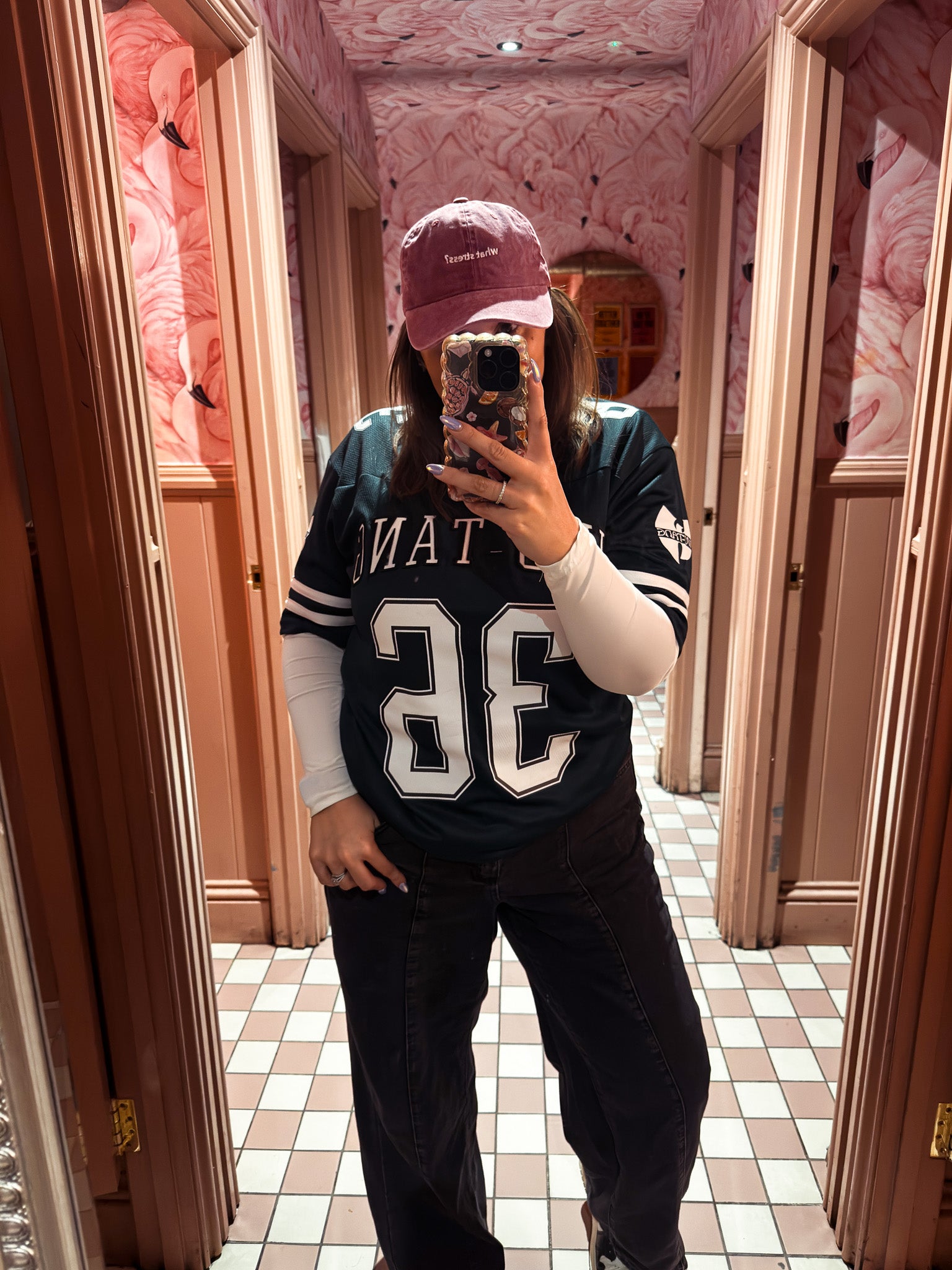 Person wearing a sports jersey and cap in a patterned room